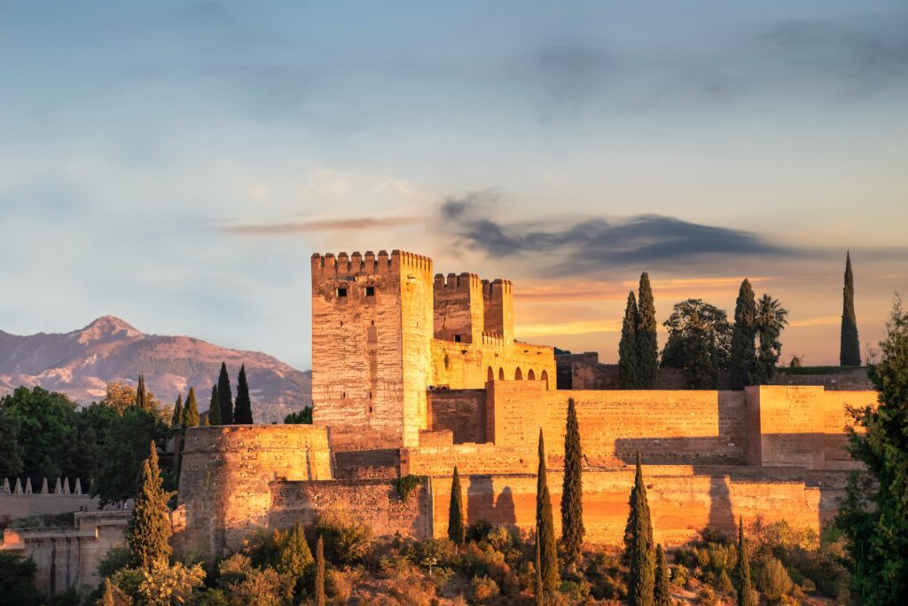Panoramic view of the Alcazaba of Málaga fortress with the Mediterranean Sea and city skyline in the background.