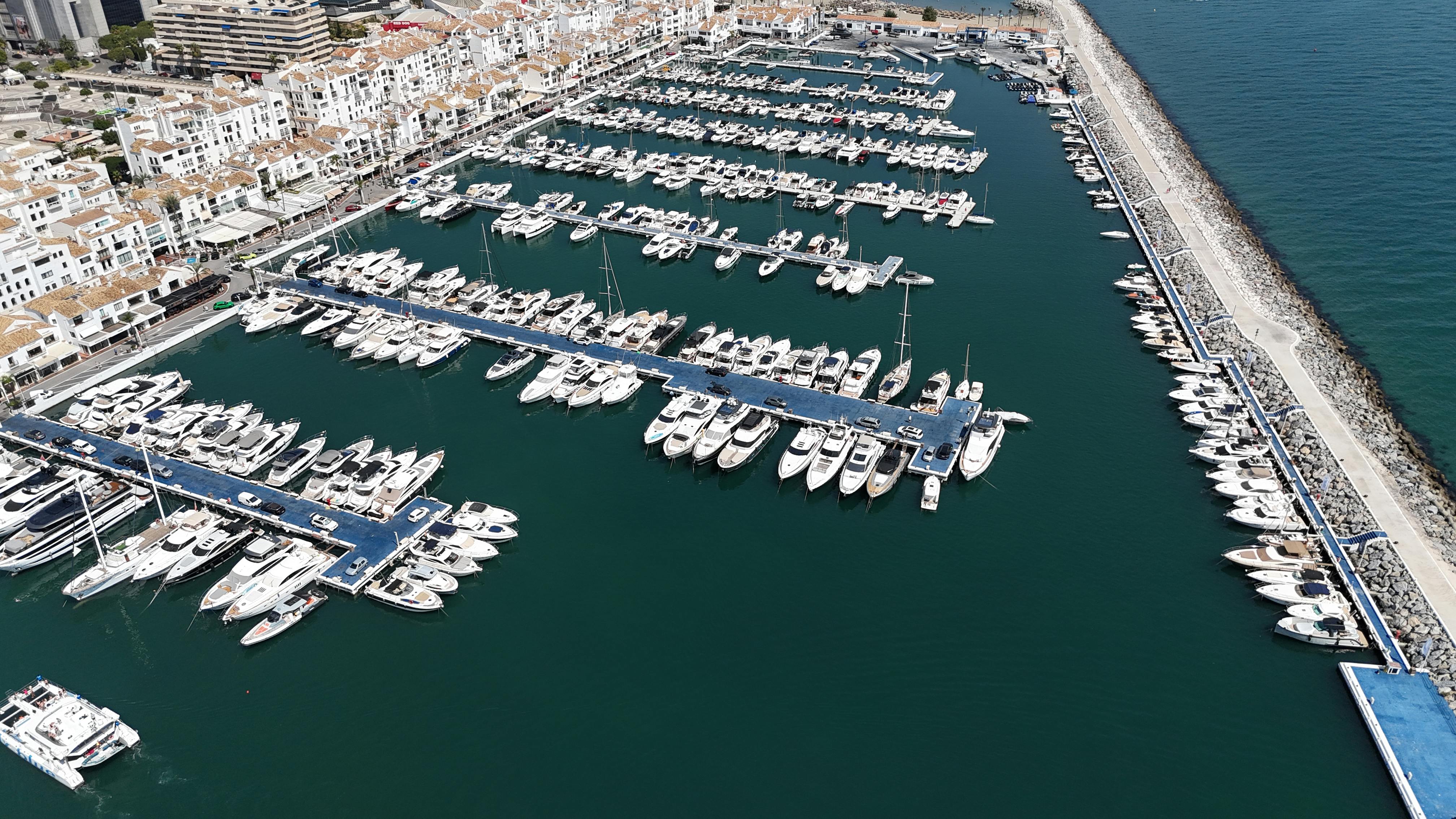 Aerial drone view of luxury yachts and superyachts docked in the marina of Puerto Banús, Marbella.