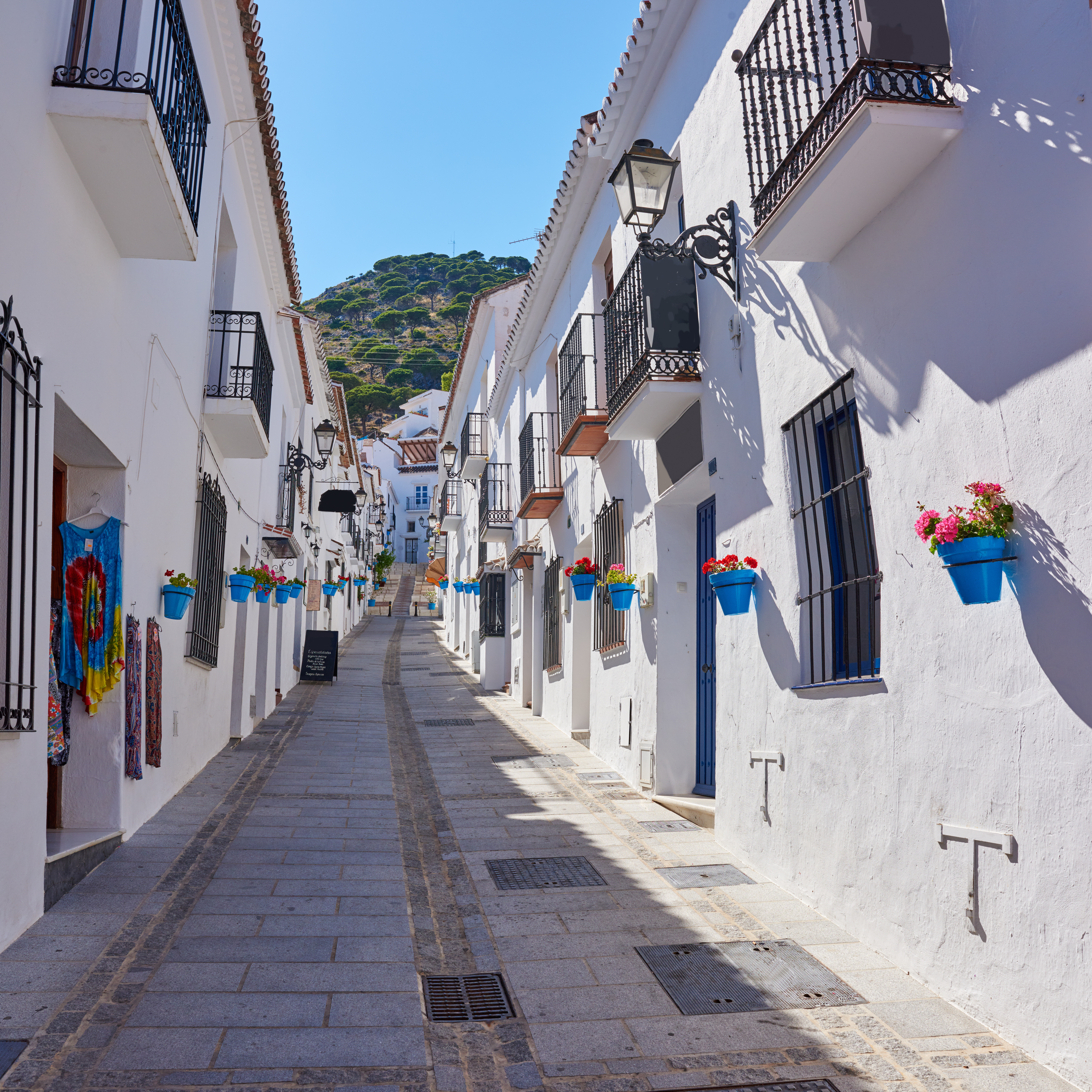 Charming narrow street with traditional whitewashed buildings in the historic old town of Mijas Pueblo, Andalusia.