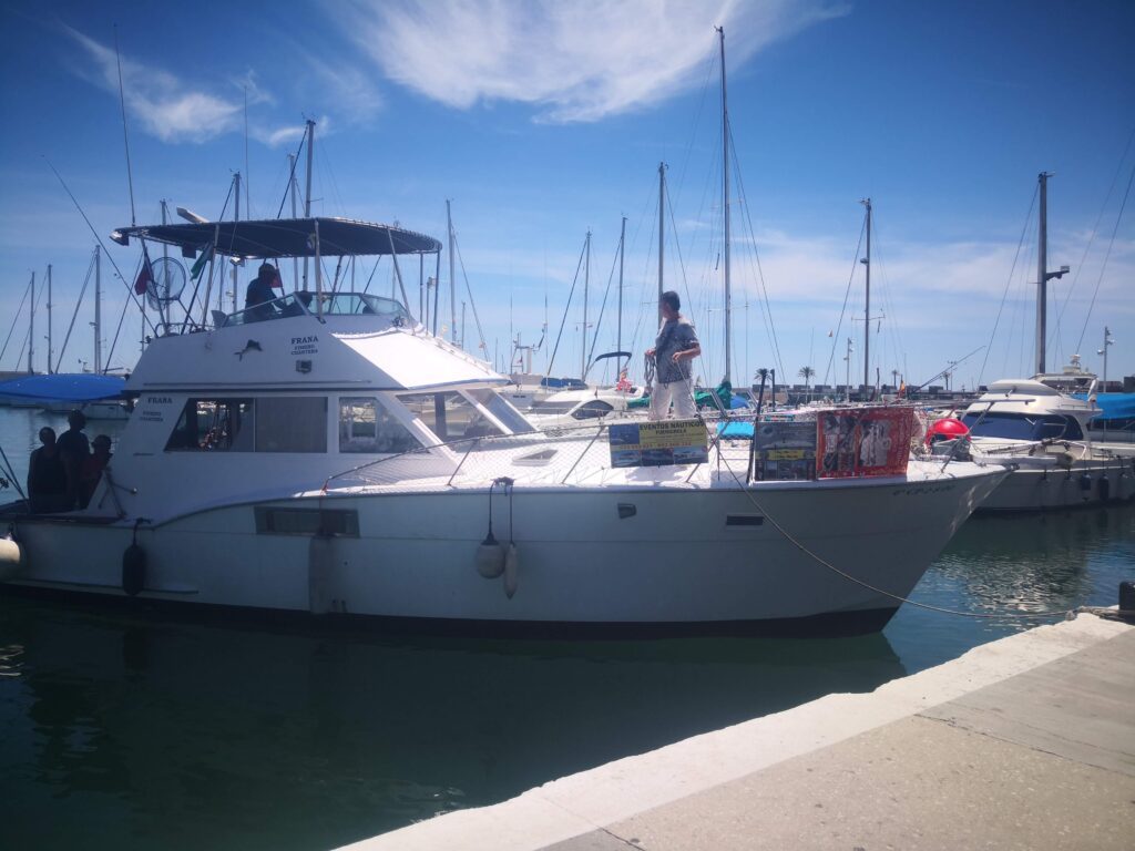 A luxury private charter boat docked in Fuengirola Marina, available for rent for coastal cruises and dolphin watching along the Costa del Sol.