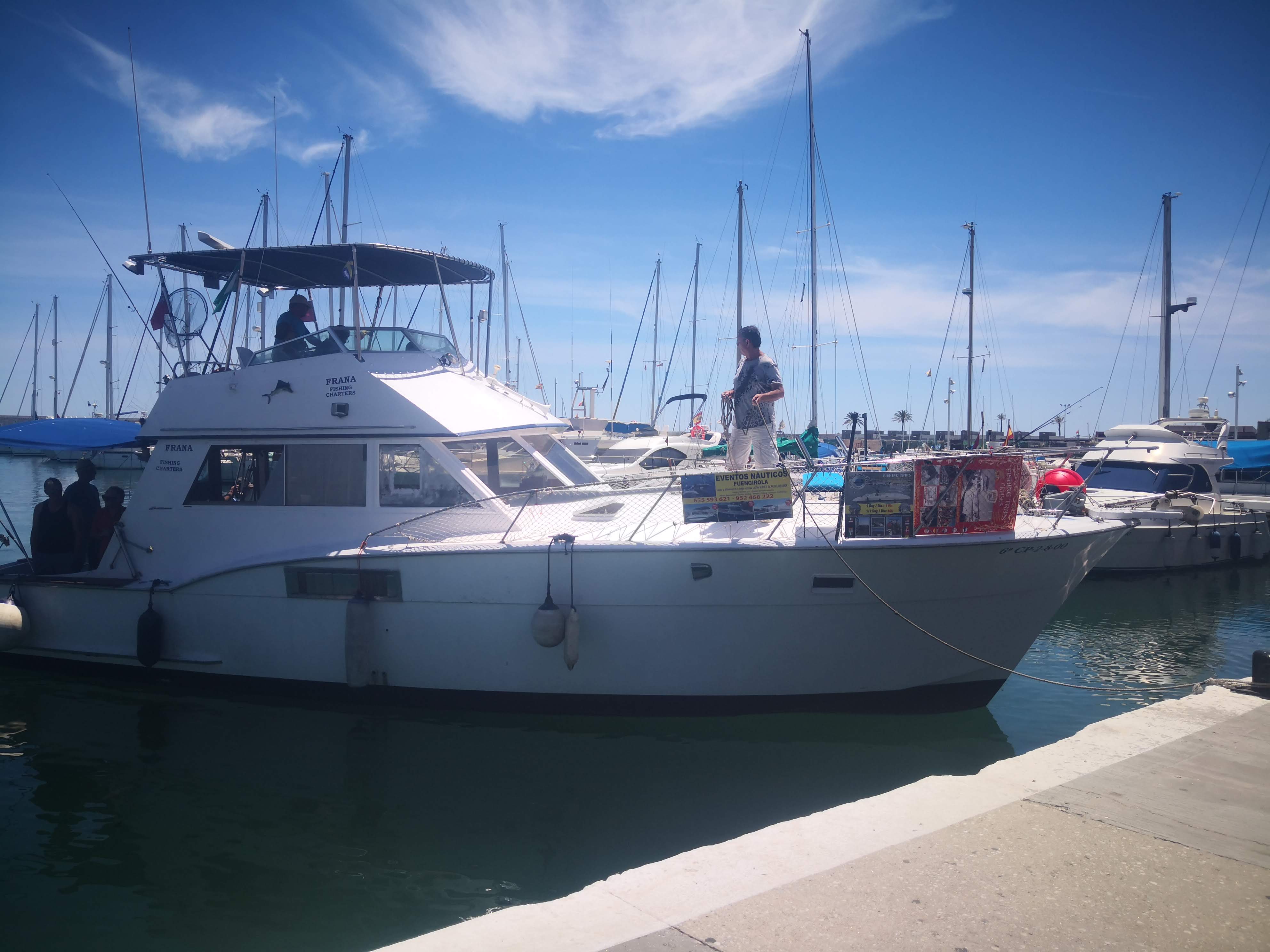 A luxury private charter boat docked in Fuengirola Marina, available for rent for coastal cruises and dolphin watching along the Costa del Sol.