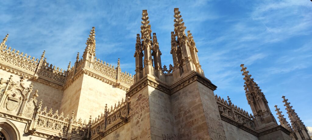 A ground-up view of the historic Granada Cathedral pinnacles stretching into the southern Spanish sky.