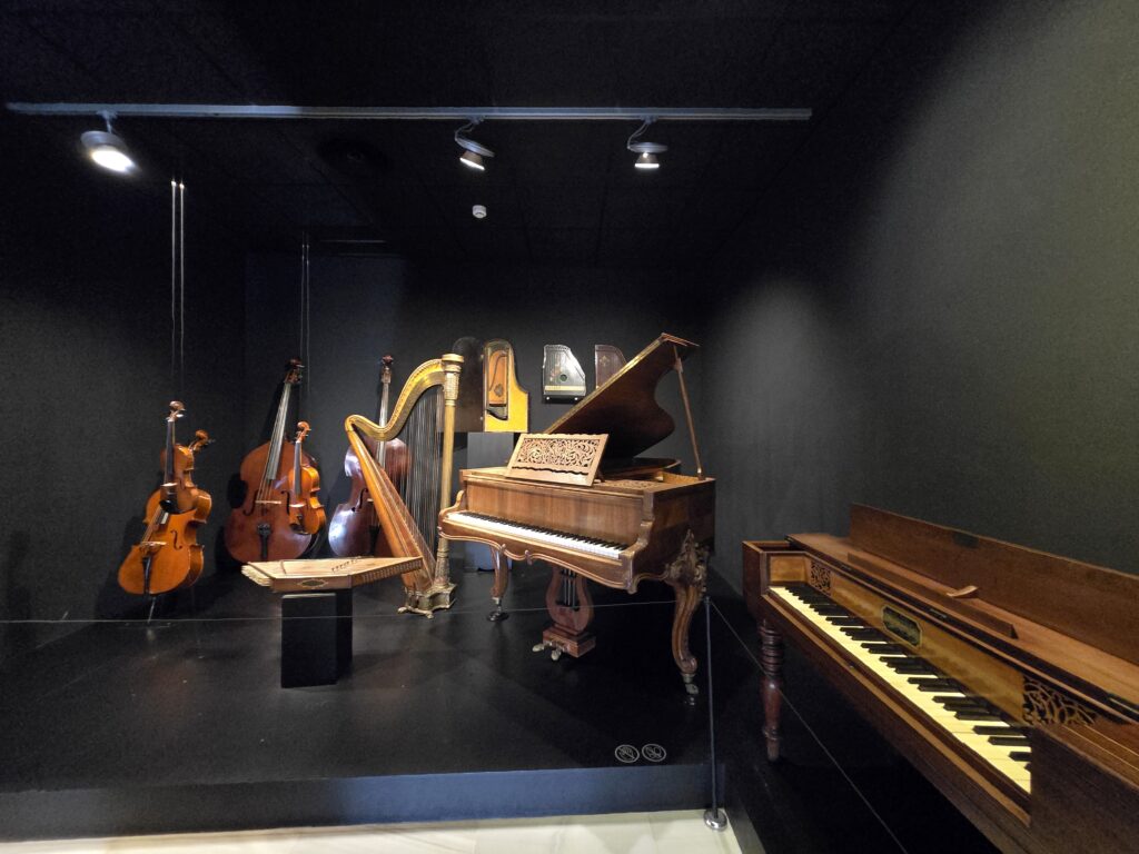 A display room filled with pianos, cellos, harps, and violins at the Interactive Music Museum in Malaga, one of the best family-friendly activities in Costa del Sol.